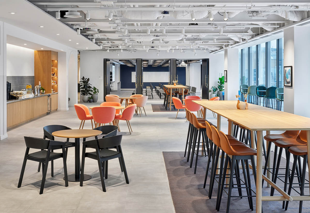 Convene London Convene London: a conference space with a presentation area and an area with tables and chairs and refreshments.