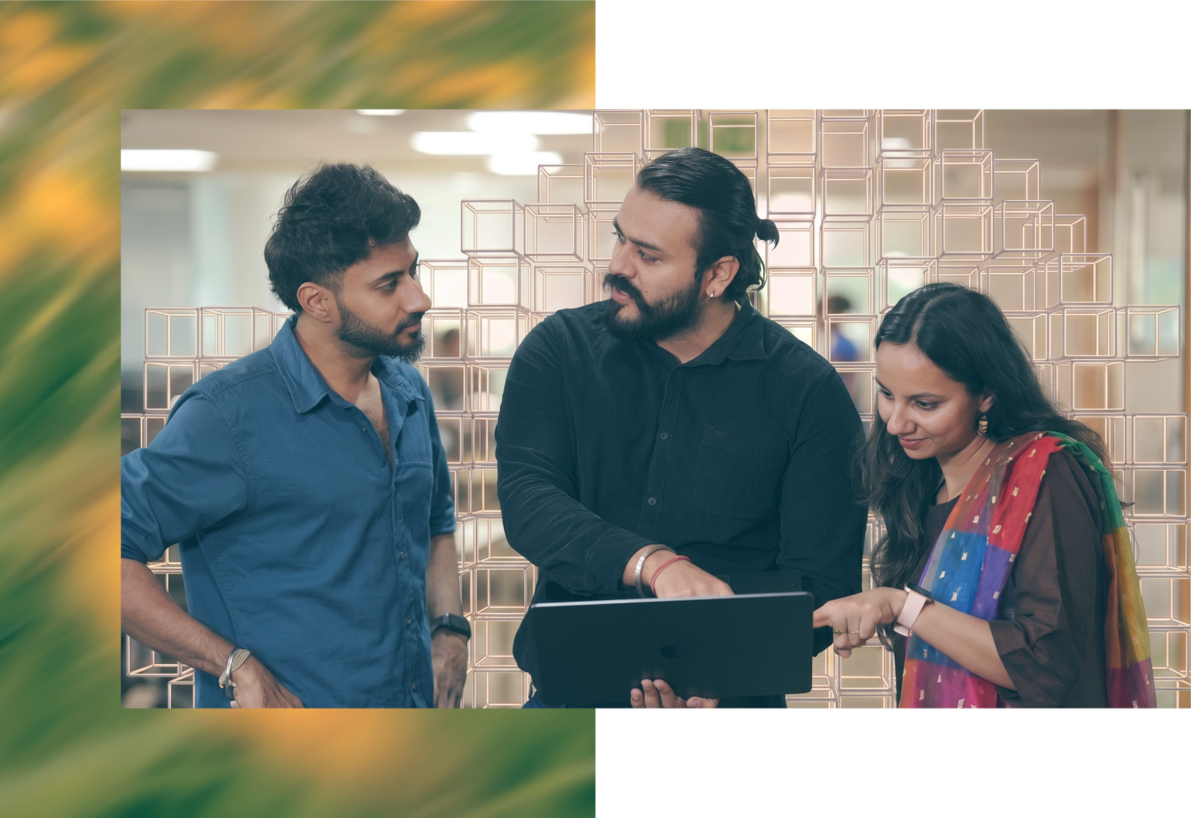 A stand up between three Thoughtworkers, grouped around an ipad. Cubes create a wall behind them