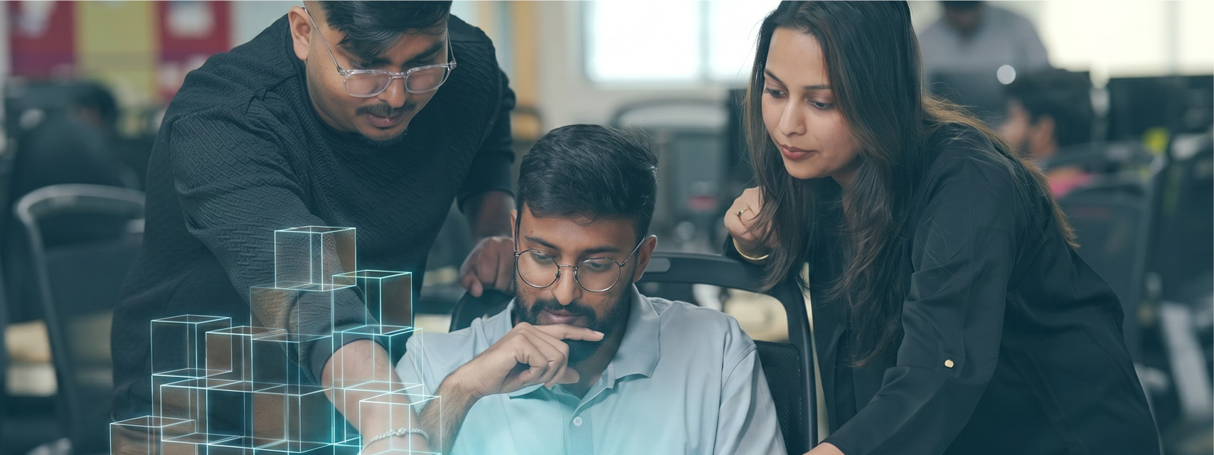Three Thoughtworkers chatting around a laptop. All have dark hair, and are wearing casual clothes - AI cubes are dancing around the laptop.
