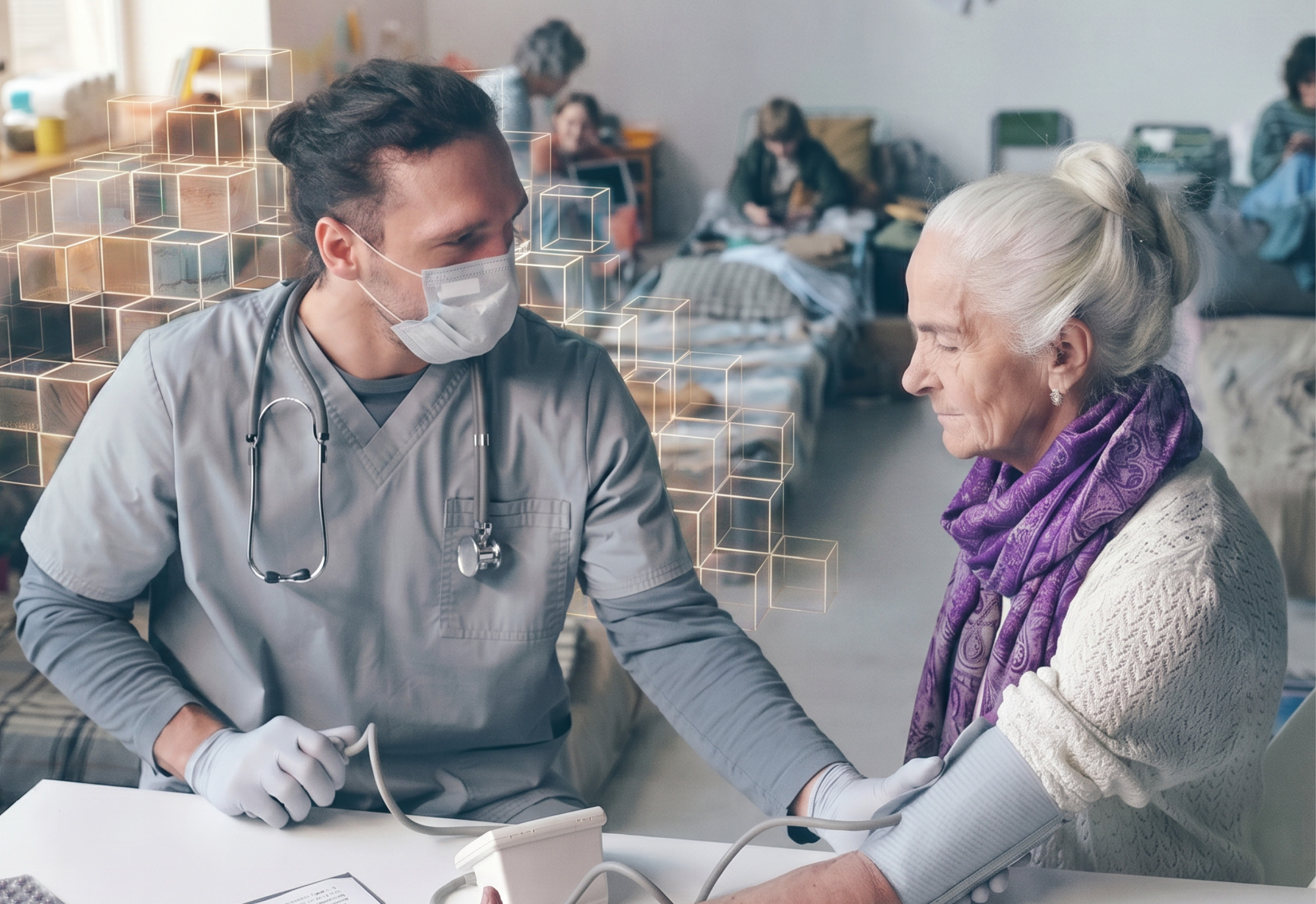 A young male medic is checking an older ladys blood pressure. They are sitting at a table in the foreground, both in grey but she has a purple scarf on. In the background are many small beds, with a group of people sitting / resting on them.