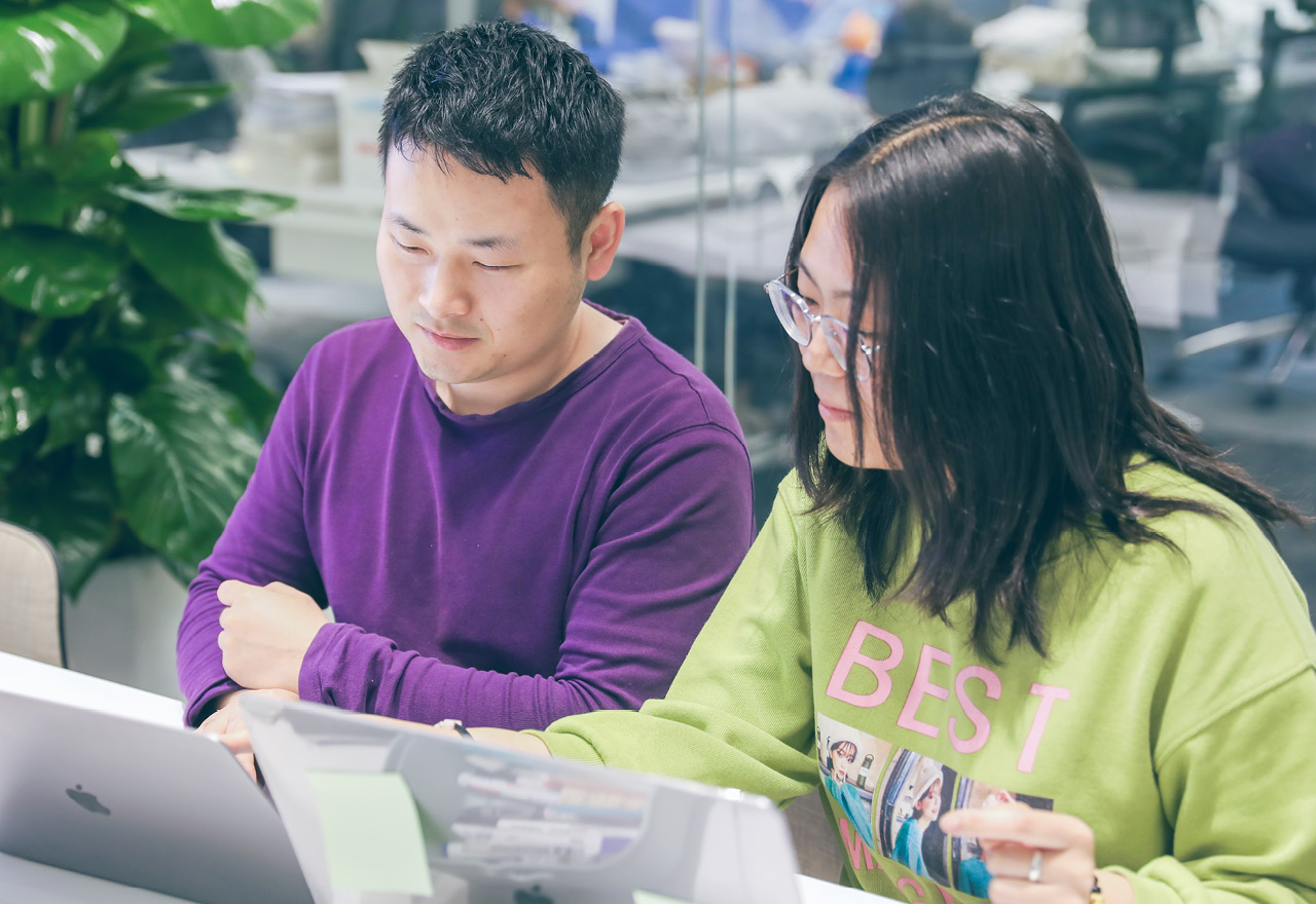 Two thoughtworkers looking at laptop