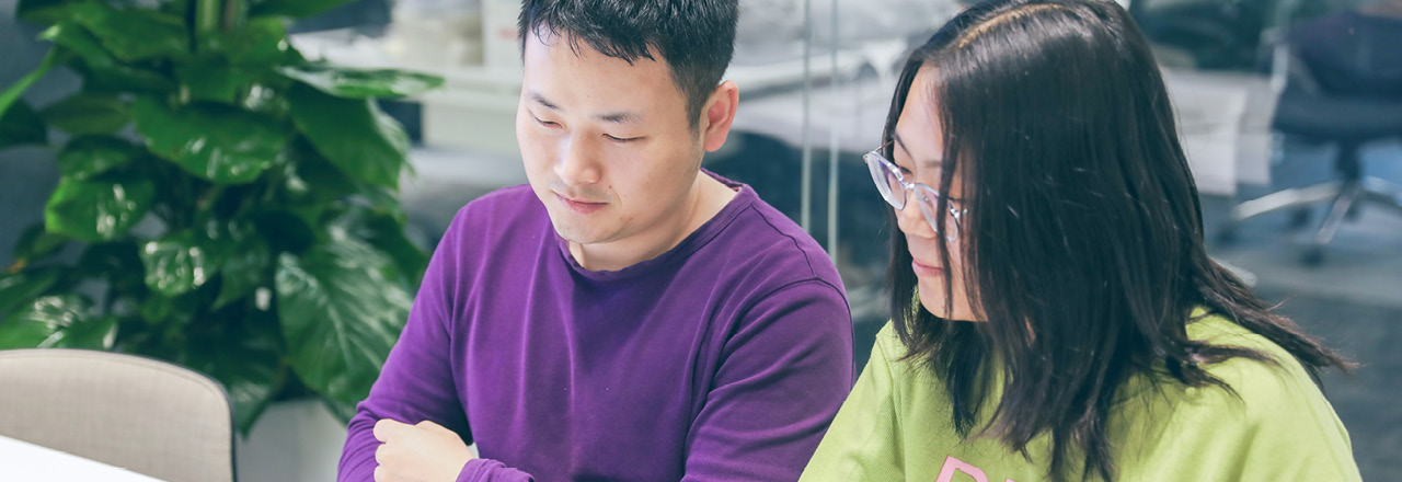 Two thoughtworkers looking at laptop