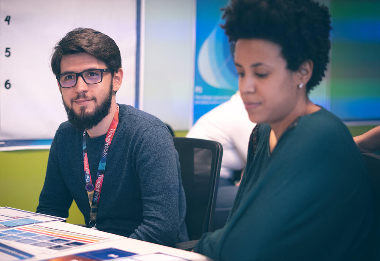 Data engineer careers Male and female Thoughtworkers sitting at a table