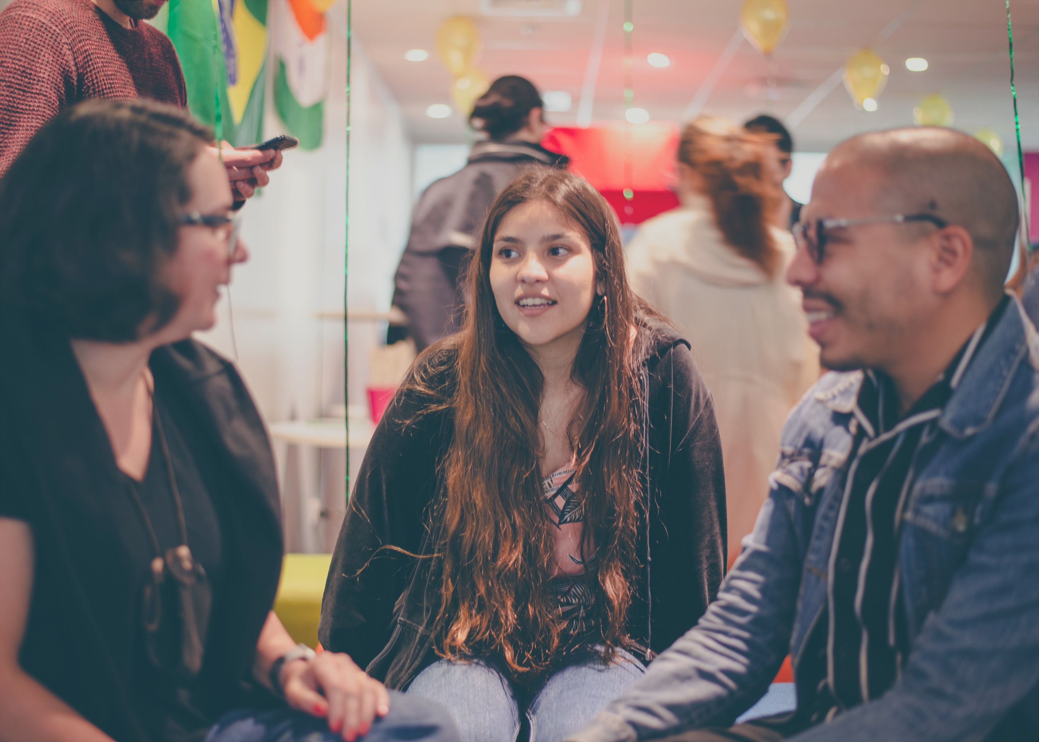 Un grupo de tres personas participa en una animada conversación en la oficina de Santiago, Chile.