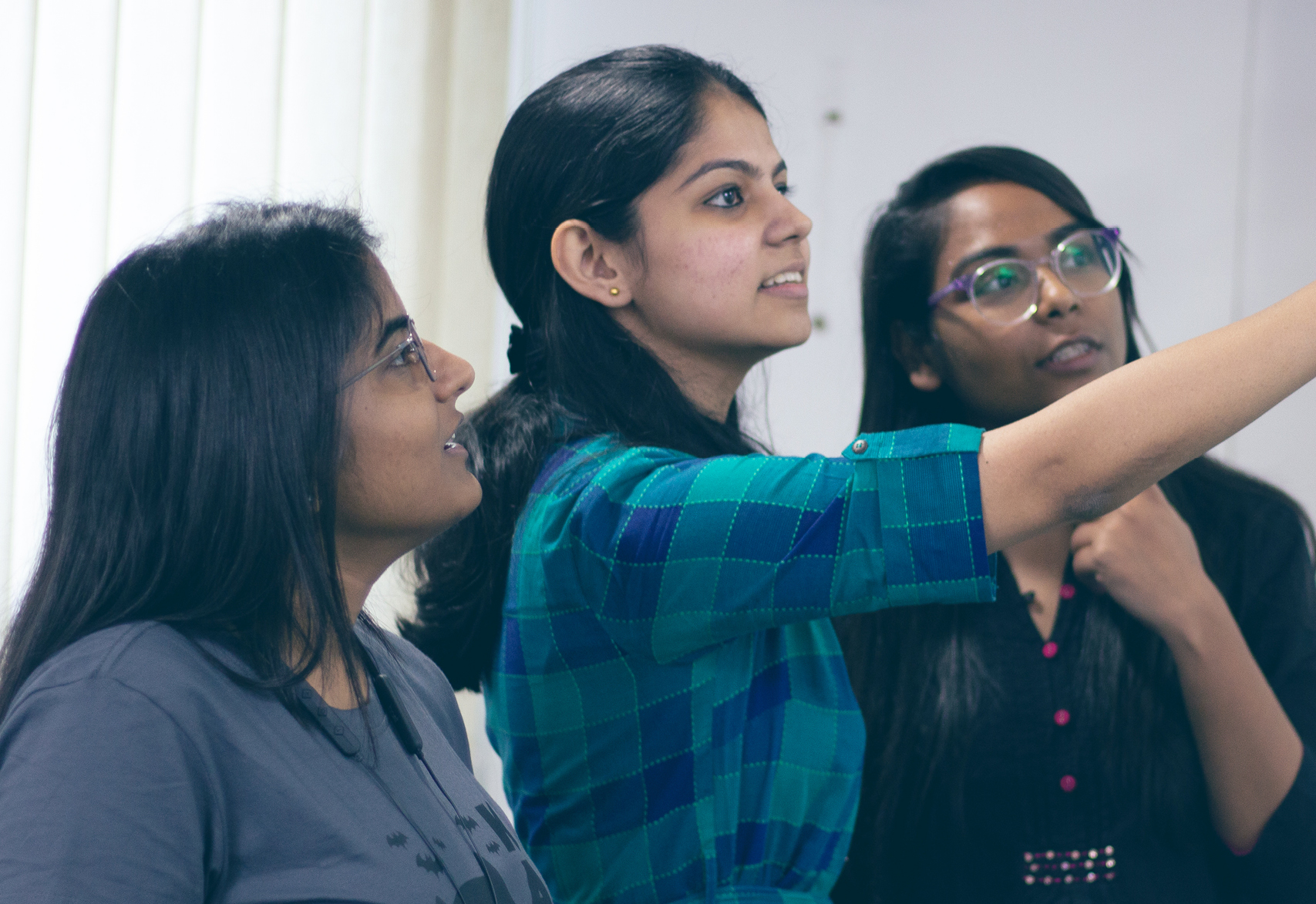 group of women standing around a standup board