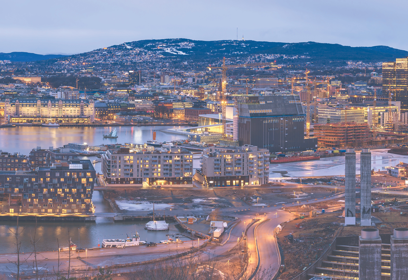 Landscape view of Oslo with city lights and cloudy purple sky