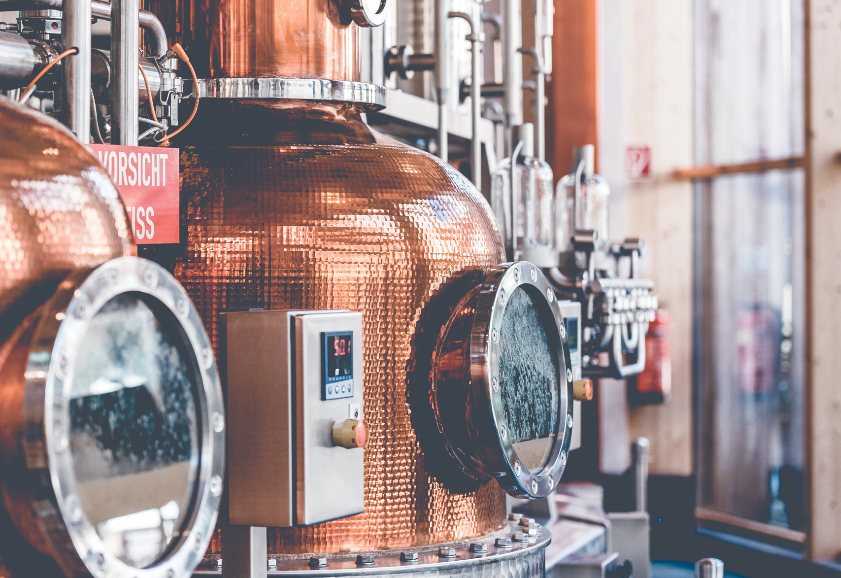 Whisky distillery factory equipment in copper color and blurred background