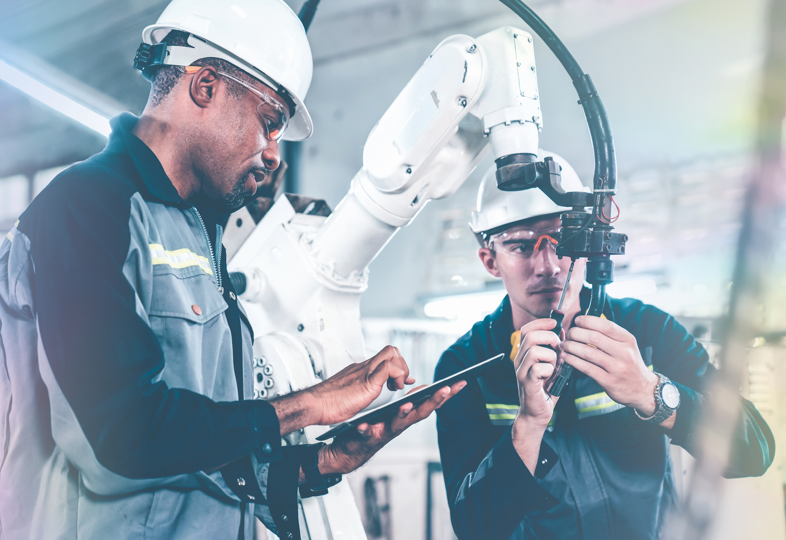 Two engineers working on a robotic arm