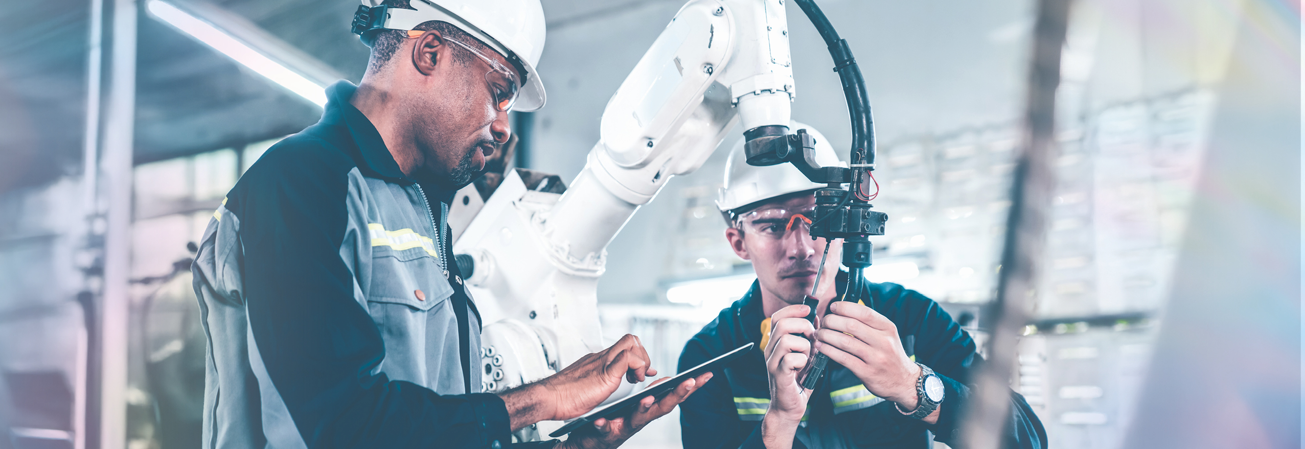 Two engineers working on a robotic arm