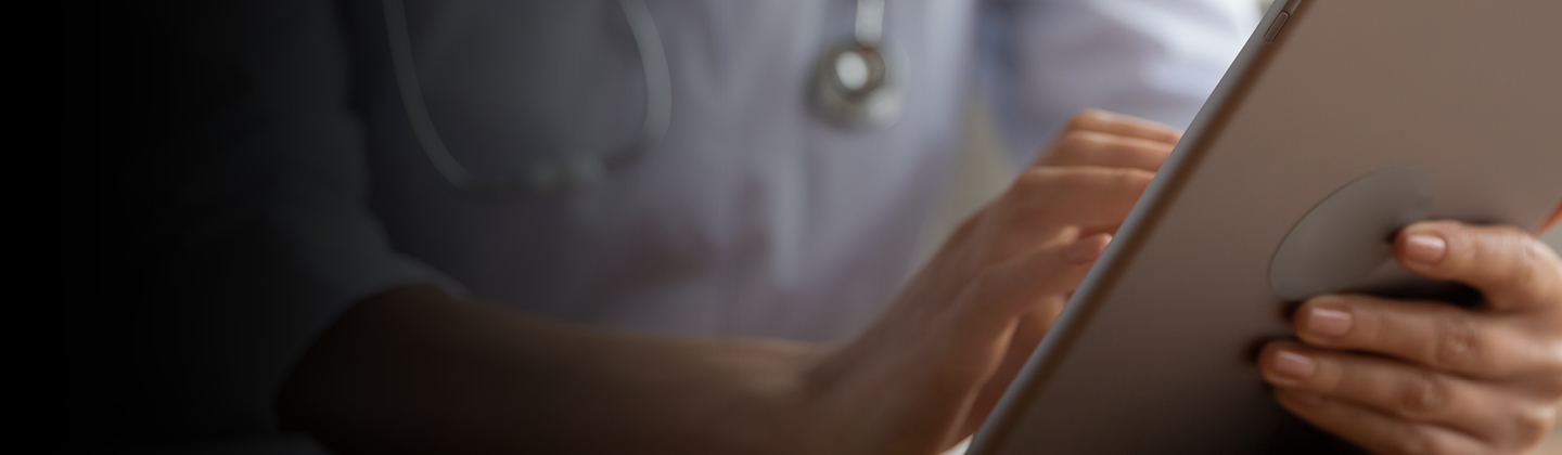 Primer plano de personal de salud utilizando una tableta para atender a un paciente