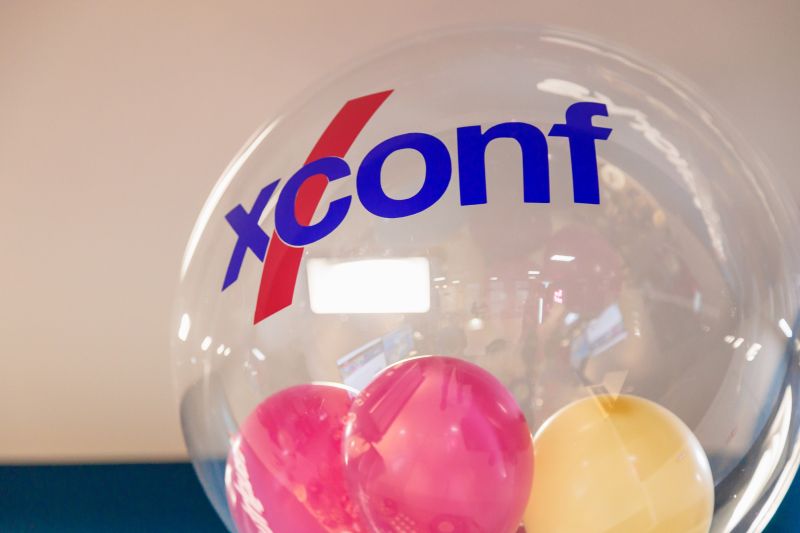 Large, clear, XConf branded balloon with three smaller, colored balloons inside