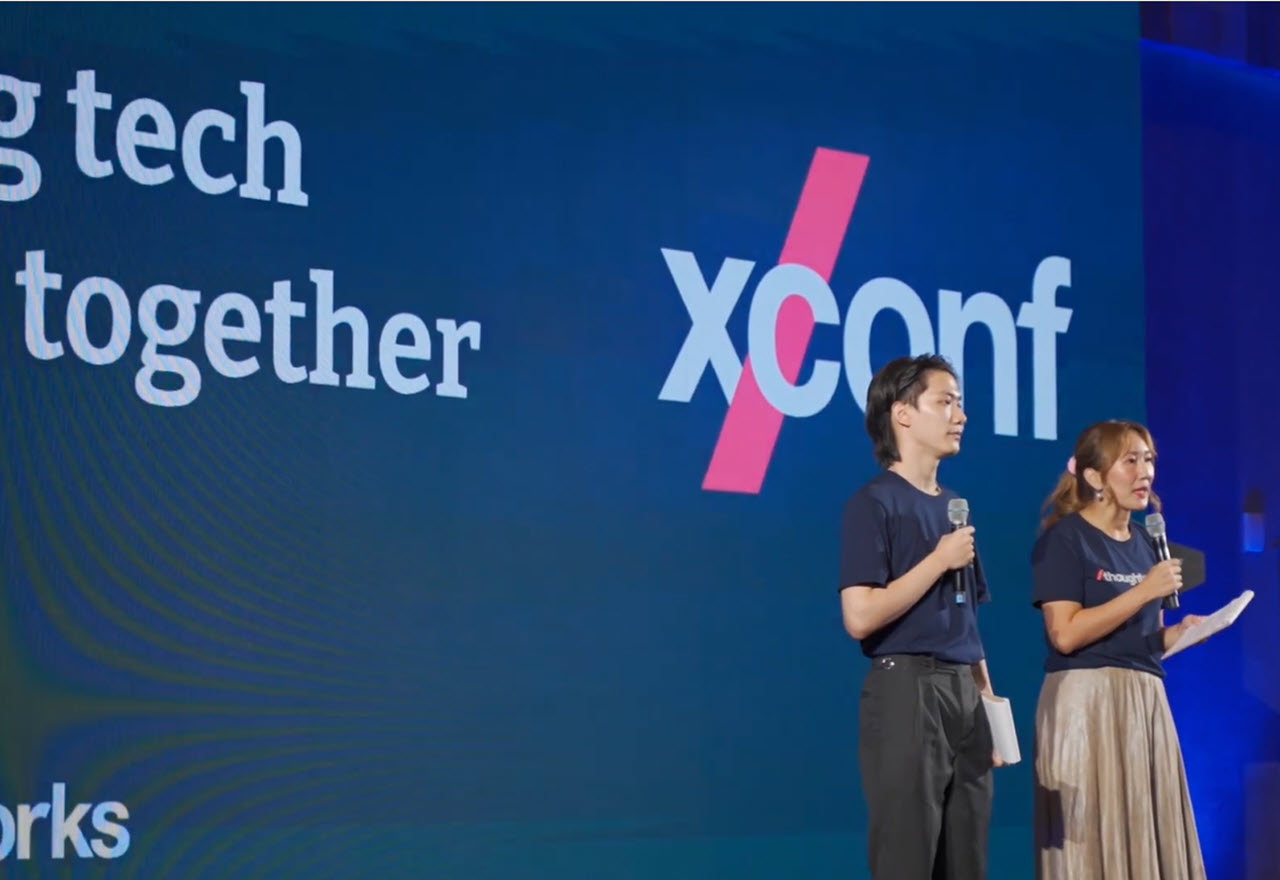 A male and a female presenter on the stage at XConf Thailand 2022