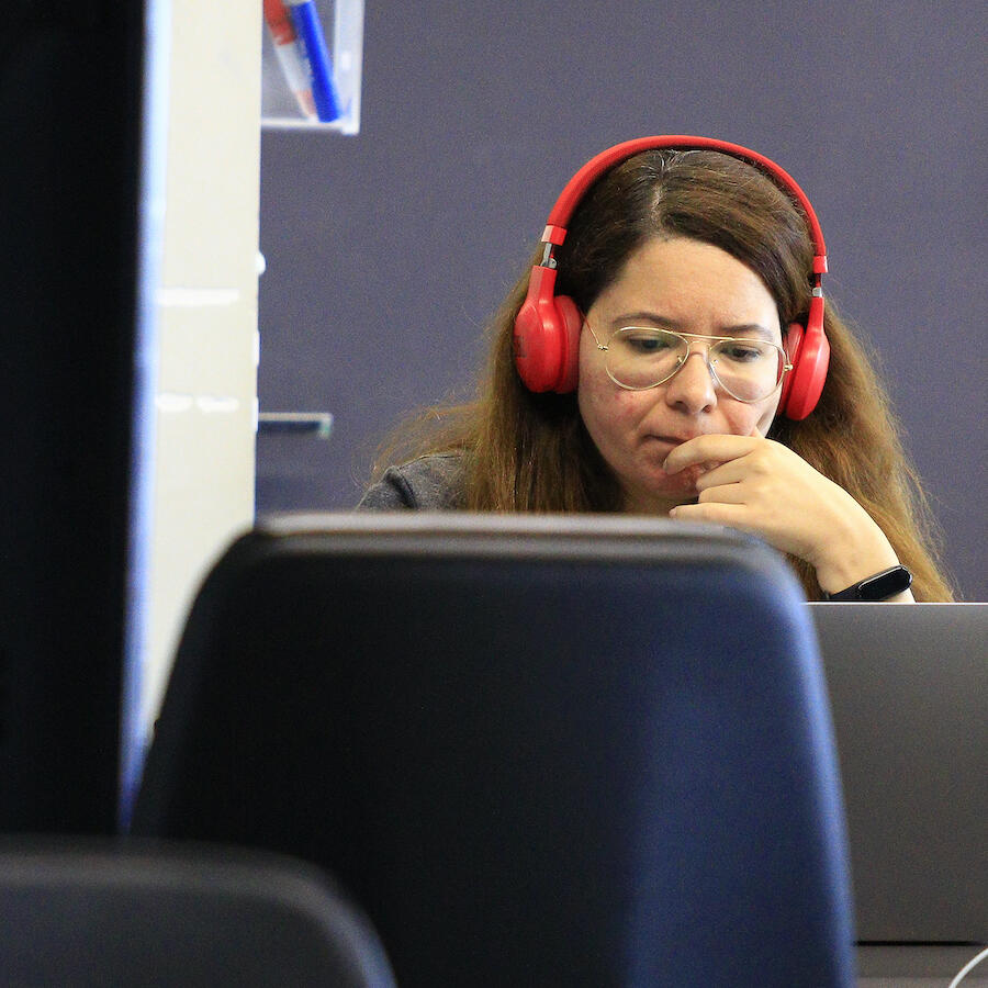 Image of a Thoughtworker listening to something on her laptop and headphones