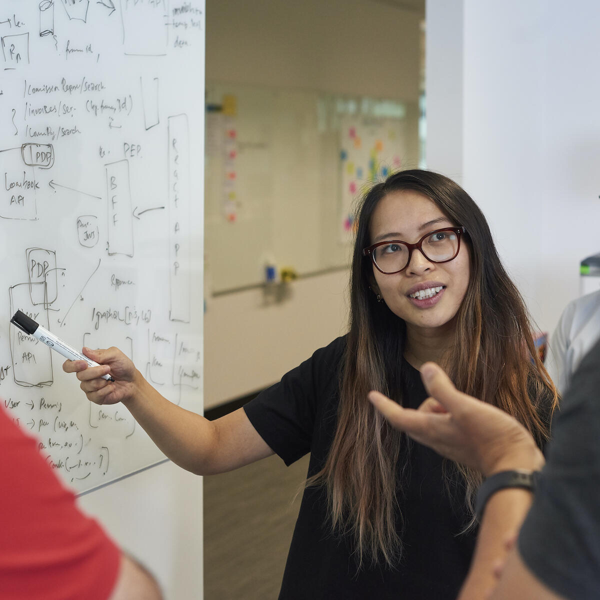 Thoughtworkers writing at a whiteboard