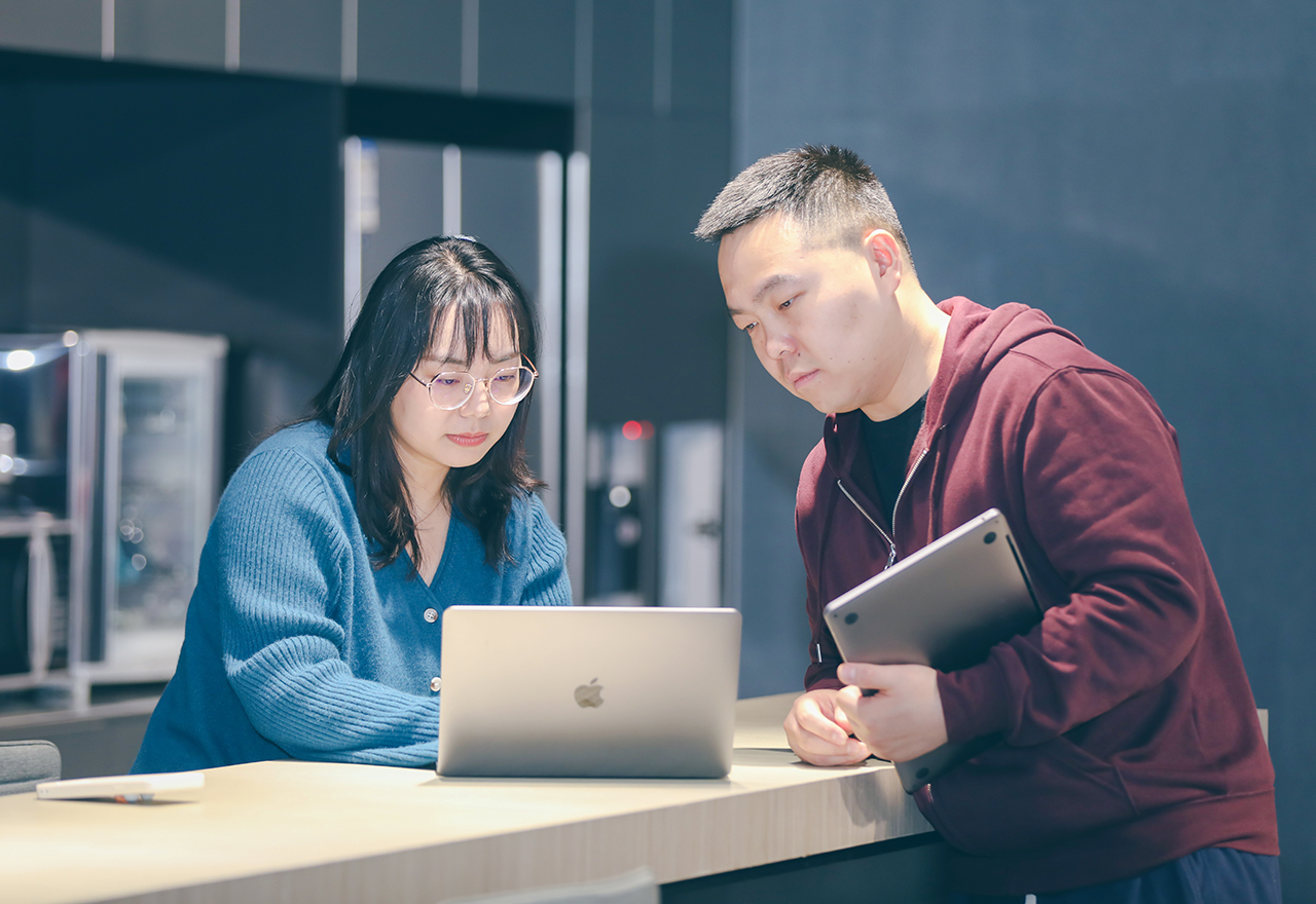 Photograph of two Thoughtworkers intent on their laptop