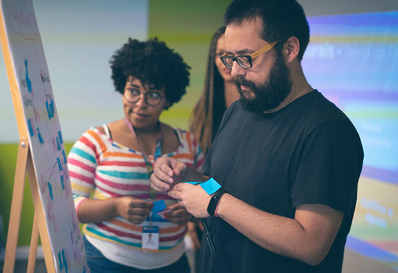 Three Thoughtworkers at a whiteboard