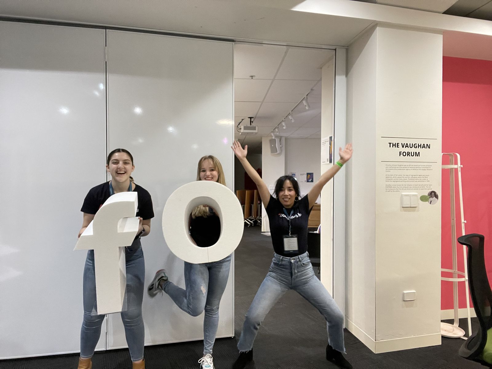 Maria Baturina at Thoughtworks University with two other Thoughtworkers holding large foam letters.
