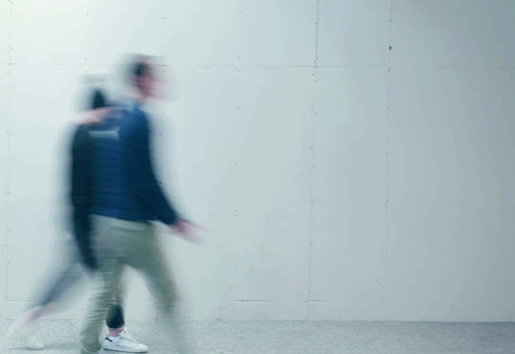 Blurred image of two people crossing a street