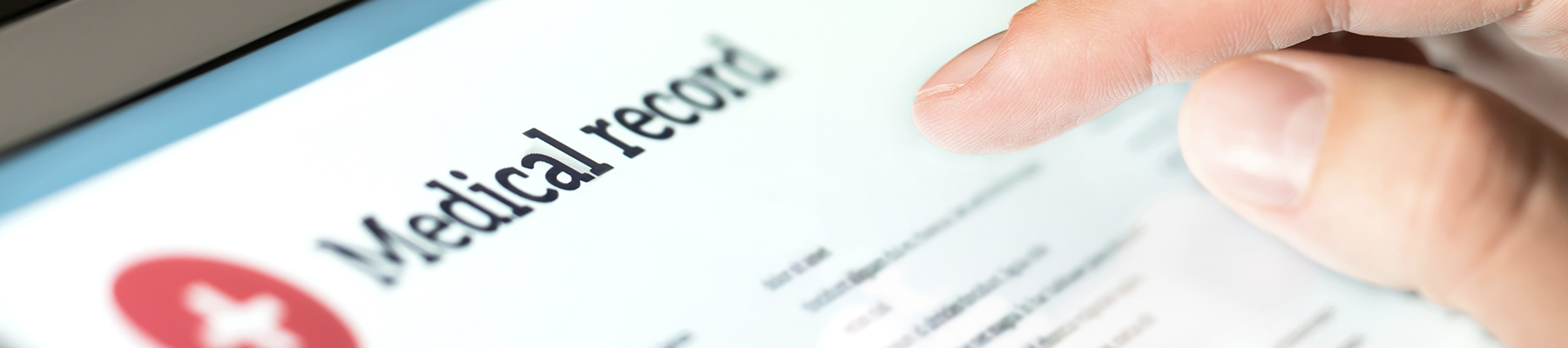 Close up of fingers on tablet screen showing word medical record