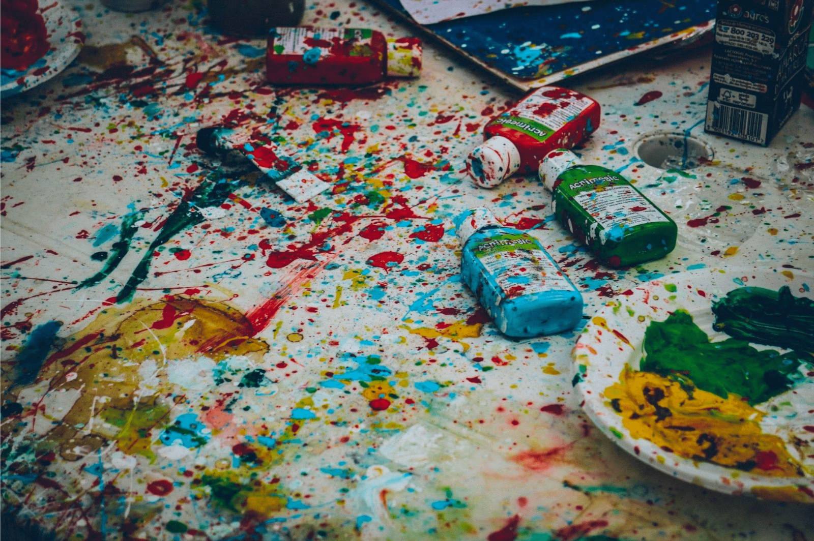 Multiple colours of paint splattered on the floor