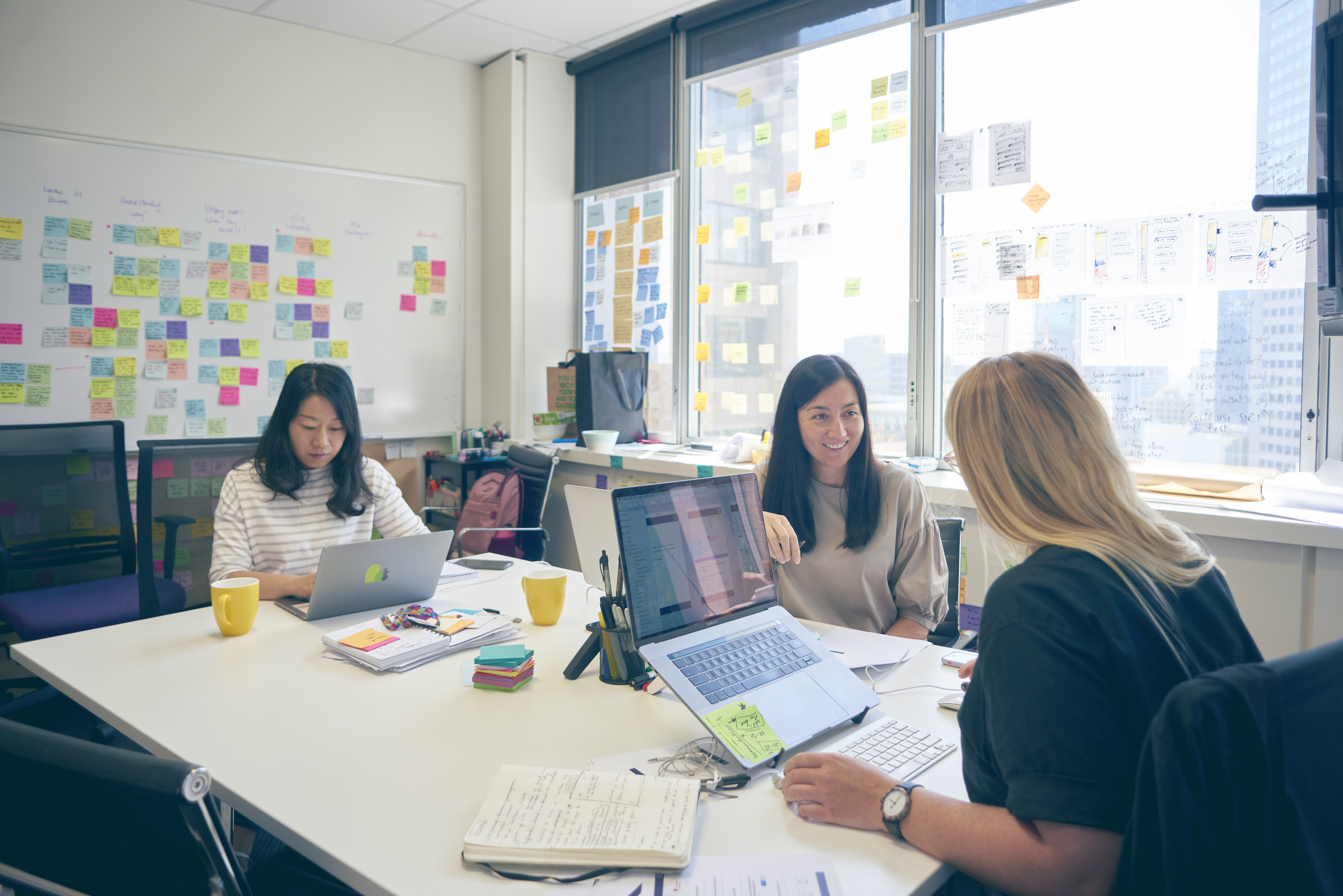 Image of Thoughtworkers sat at a table, working. 