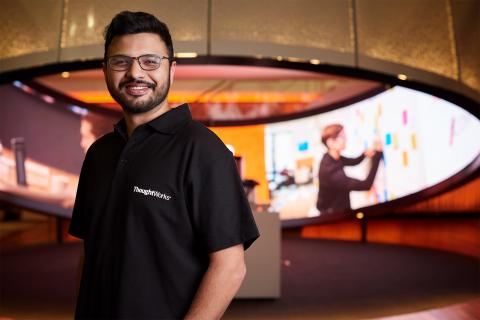 Satyam satndign in front of an LED picture