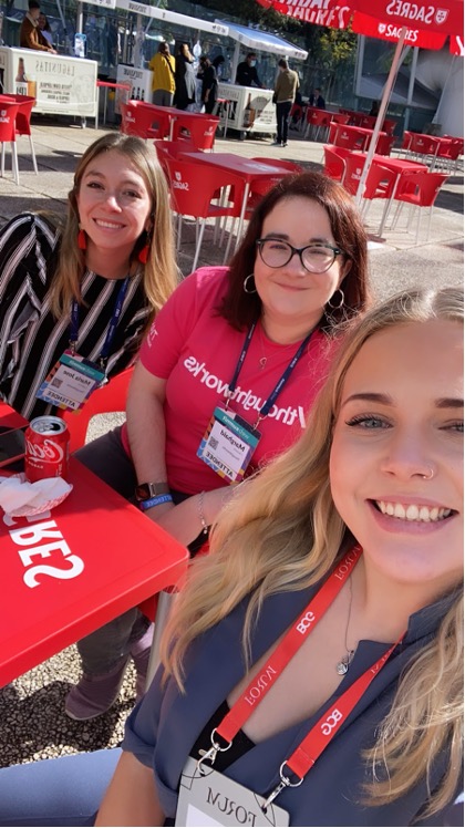 Image of Ella and two Thoughtworkers smiling at the camera. They are at Web Summit. 