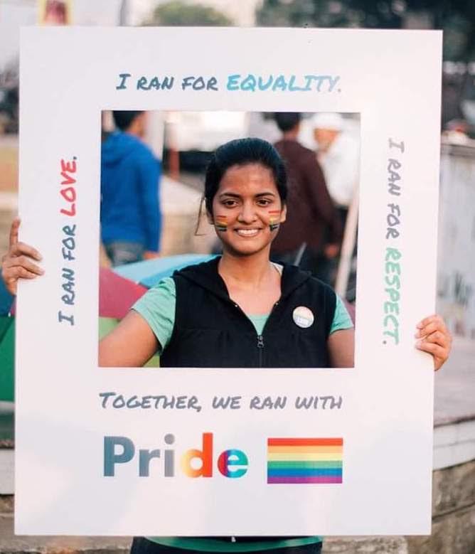 Archana, the author holding a pro LGBTQ sign at a public event