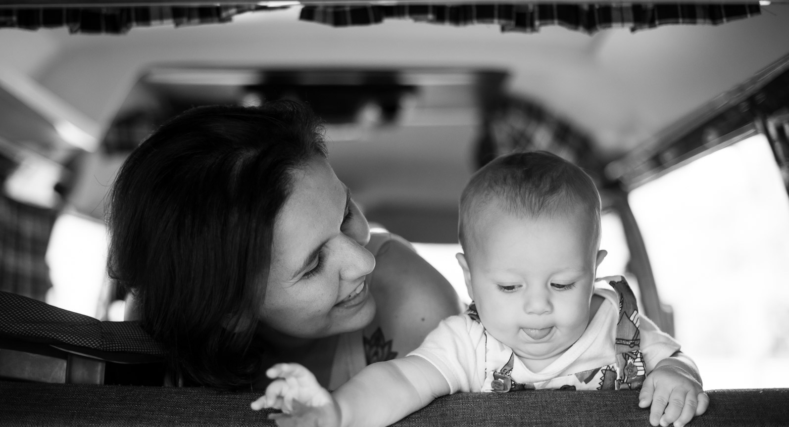 Foto em preto e branco de Marina Moscheta (Autora) olhando para sua criança.