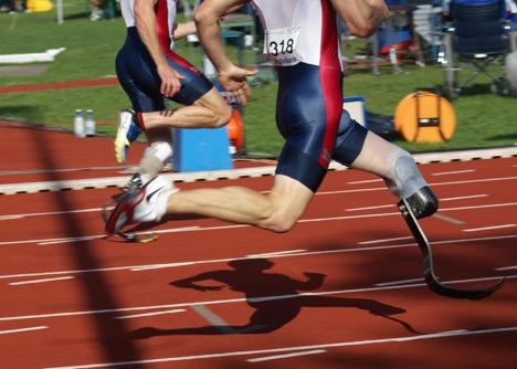 An athlete runs with a prosthetic leg on a running track