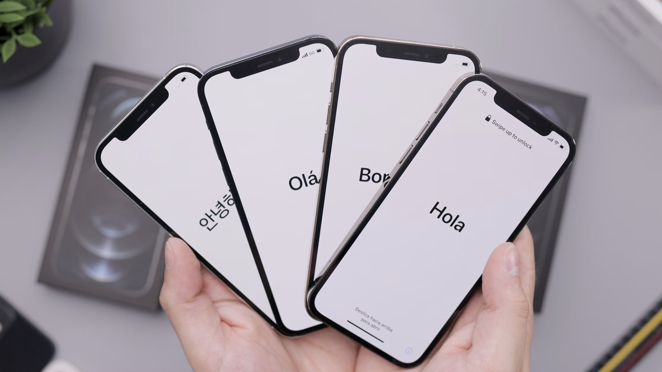 Duas mãos segurando quatro iPhone