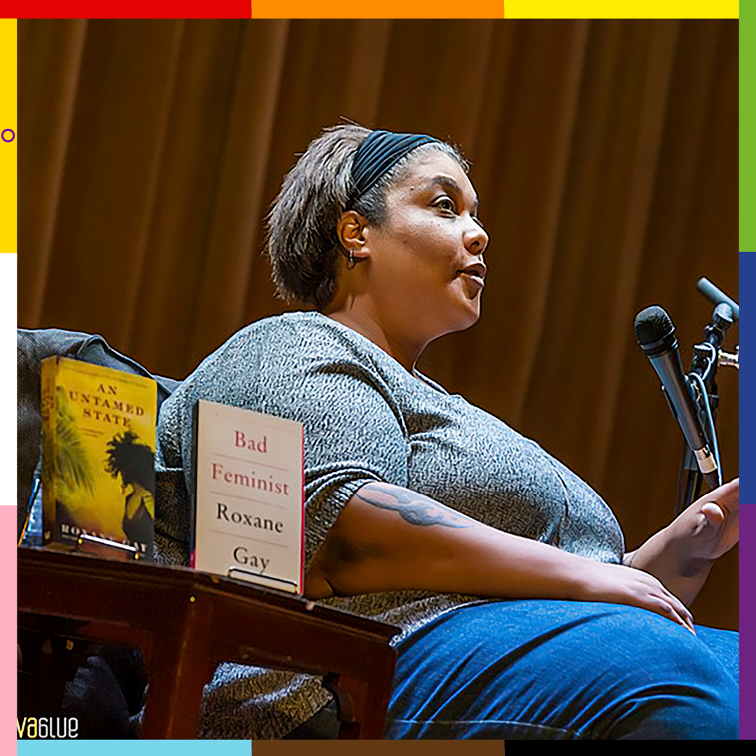Roxane, a woman sitting on a chair with a mike next to her. Her books, Bad Feminist and An Untamed state are displayed ion a stool to her right.