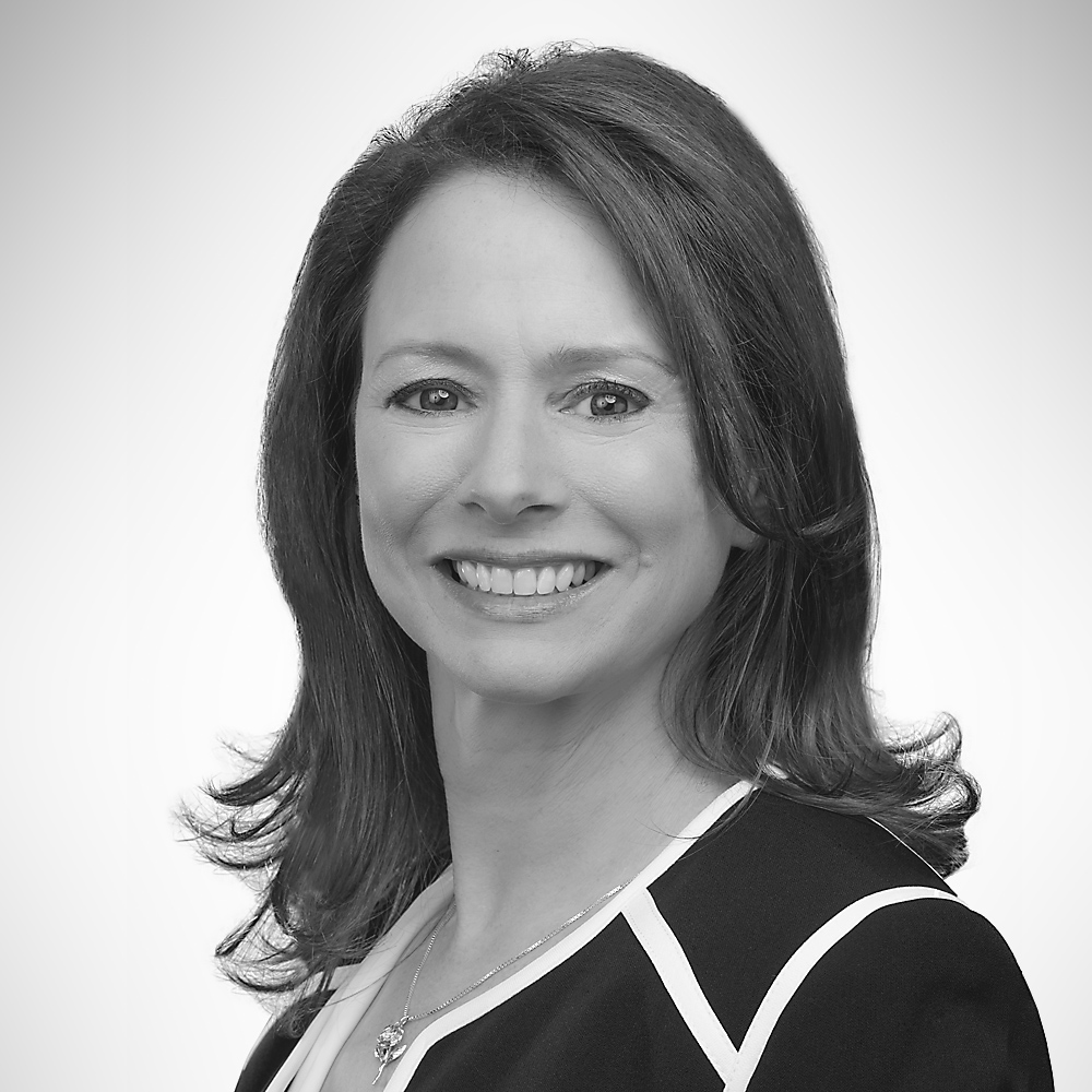 Amy Grace with long dark hair and a black blouse trimmed in white.
