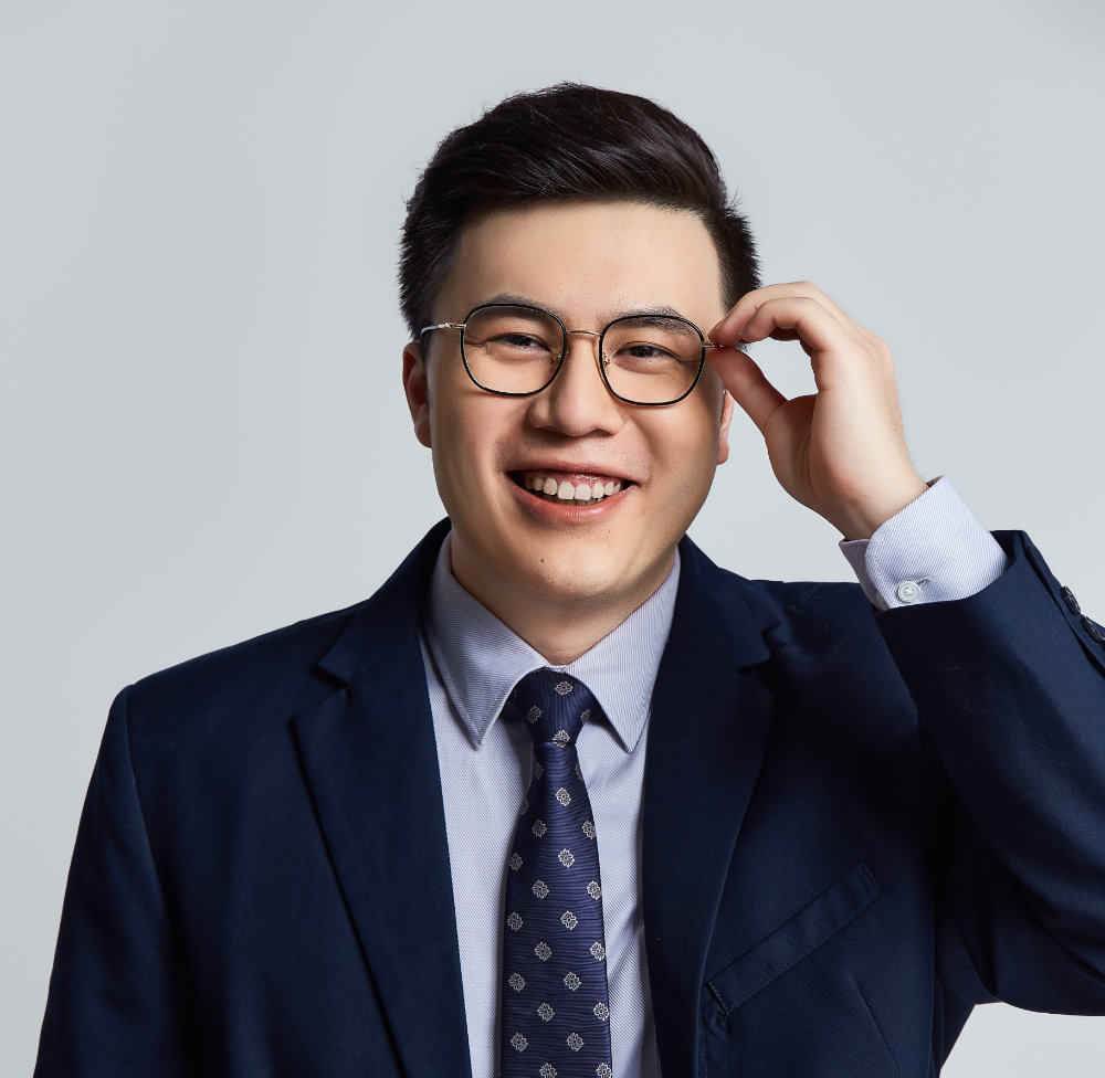 Image of Chen Meng smiling while holding his glasses