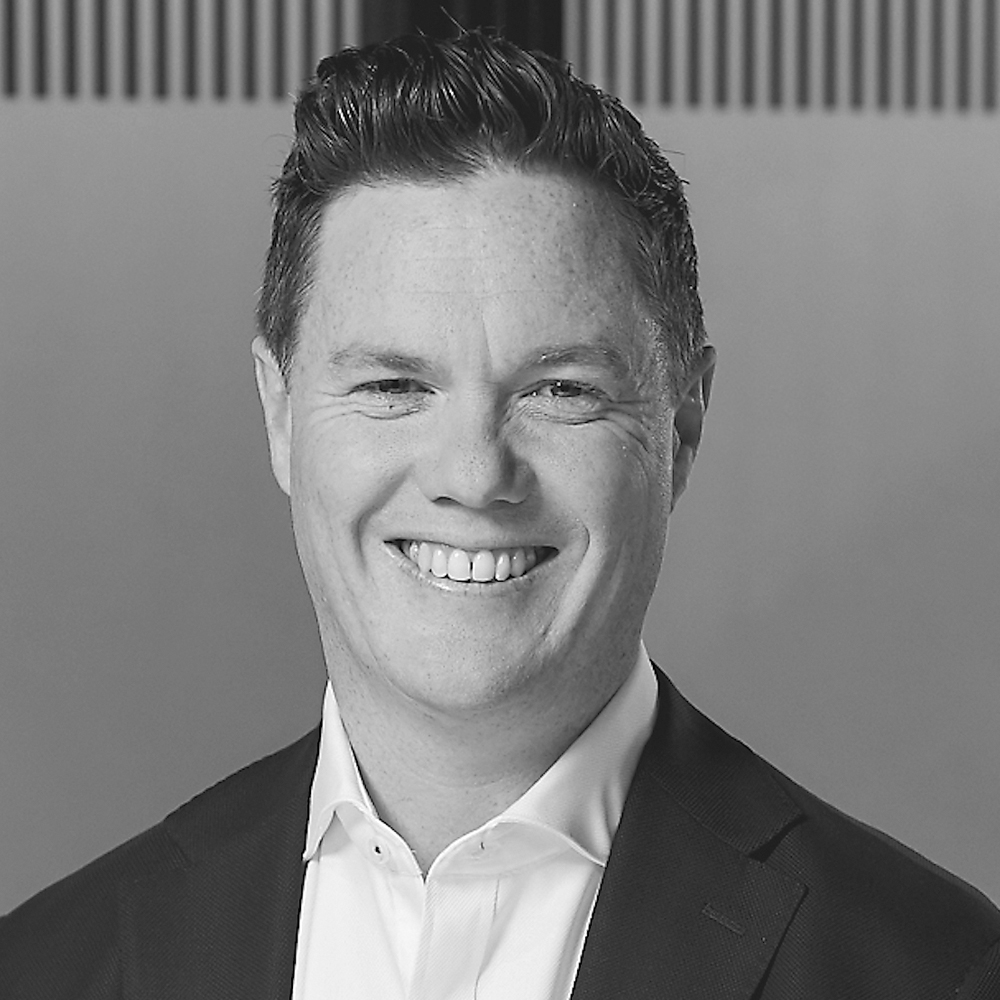 Darren Smith wearing a dark blazer and white button up shirt.