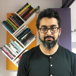 Eduardo Meneses in front of bookshelves