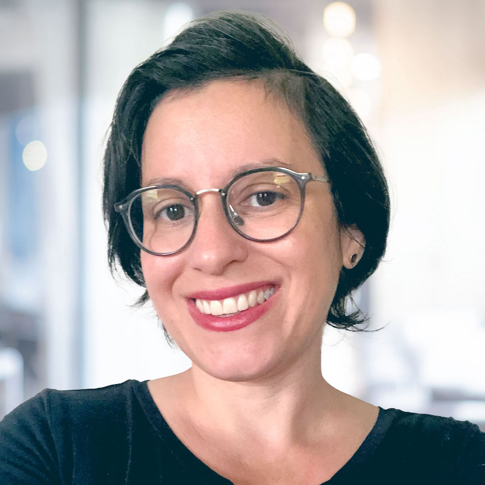 Photograph of Elise's head and shoulders - she is smiling, looking directly at the camera