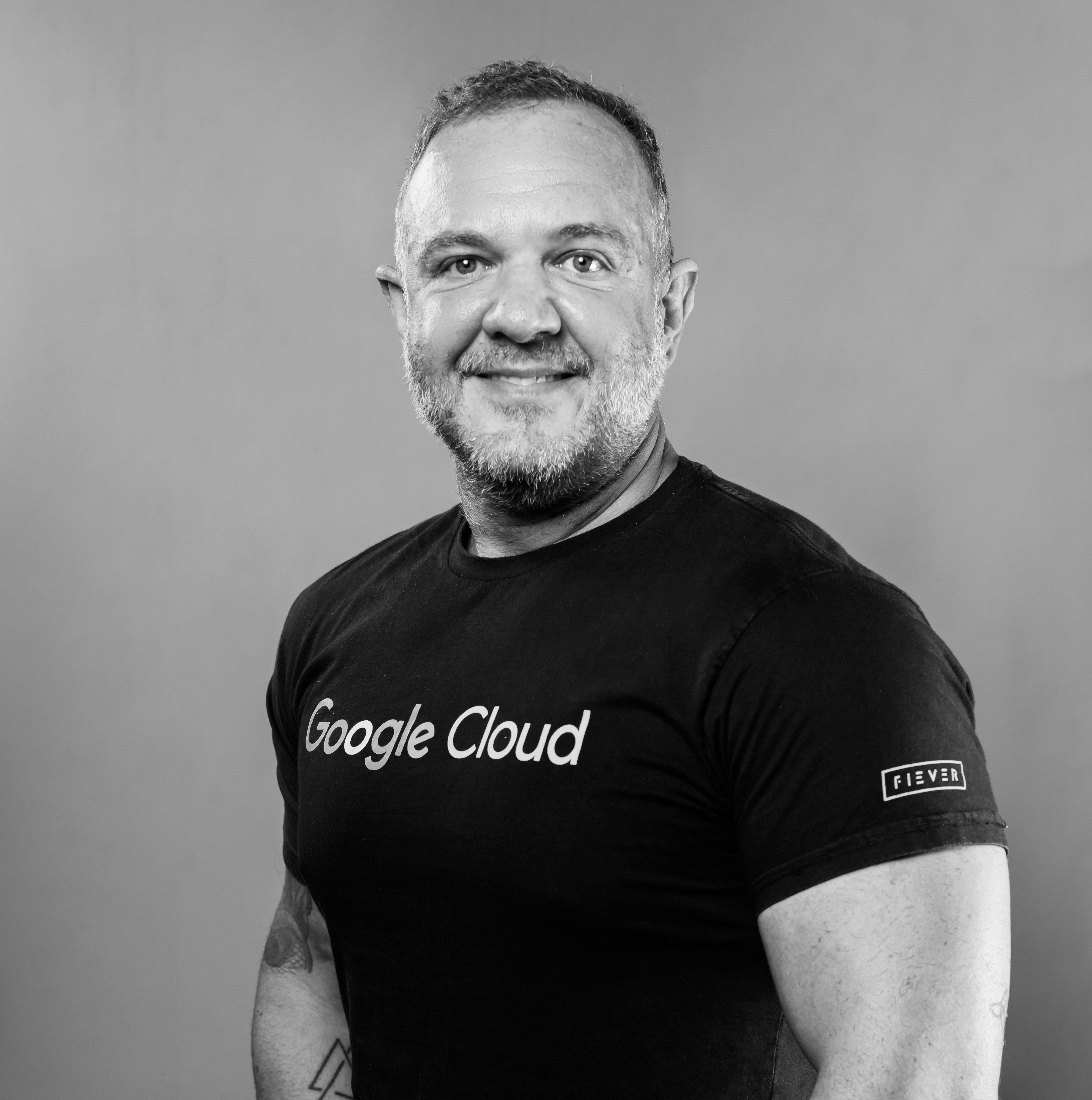 imagem-em-preto-branco-de-rosto-de-um-homen-em-pé-de-perfil-sorrindo-com-camiseta-preta-do-google