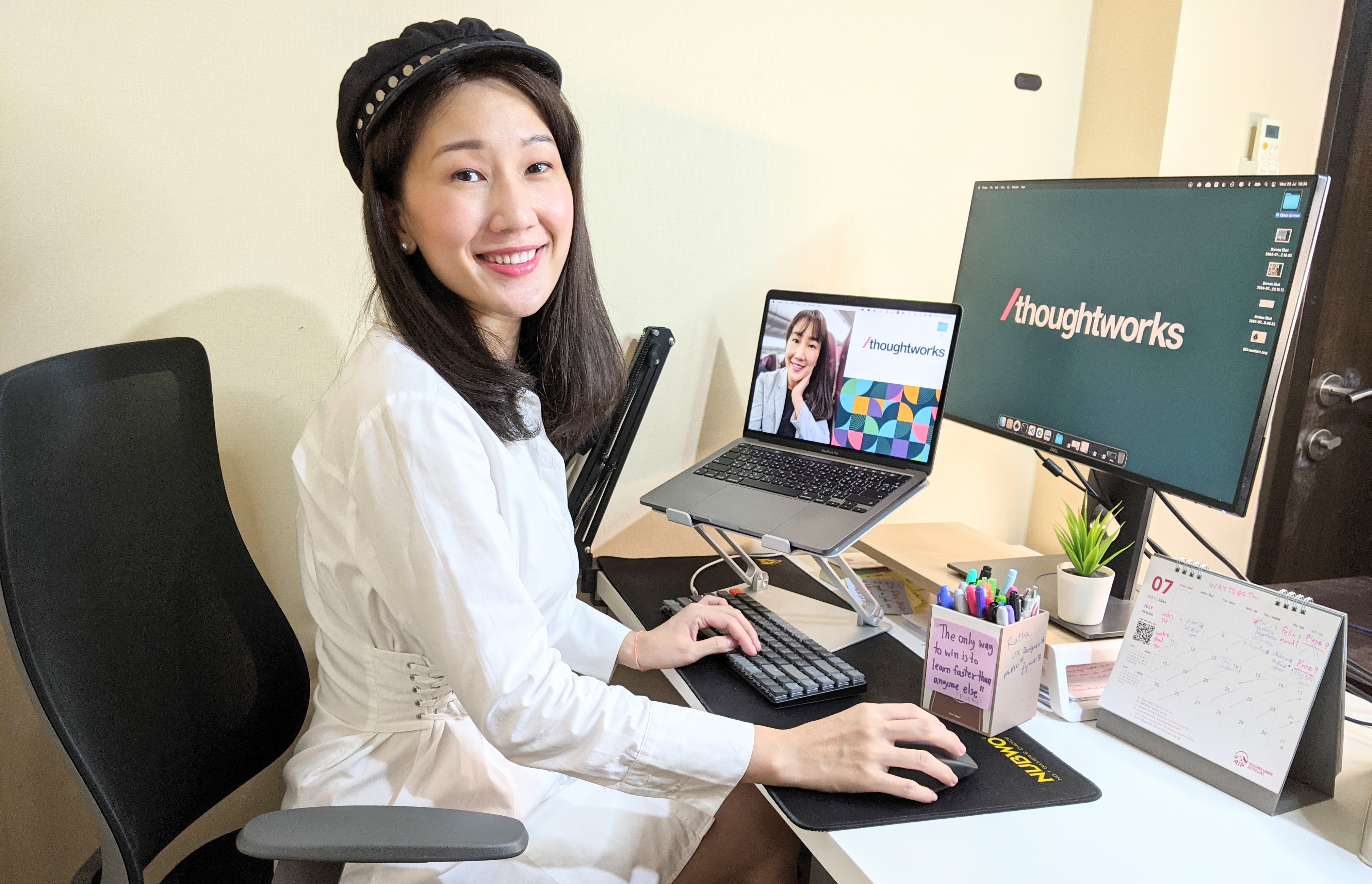 Image of Ratta on a laptop in a desk chair, smiling at the camera