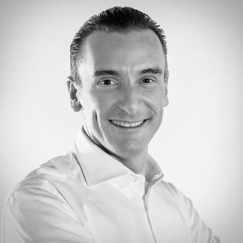 Man with dark hair and white collared shirt