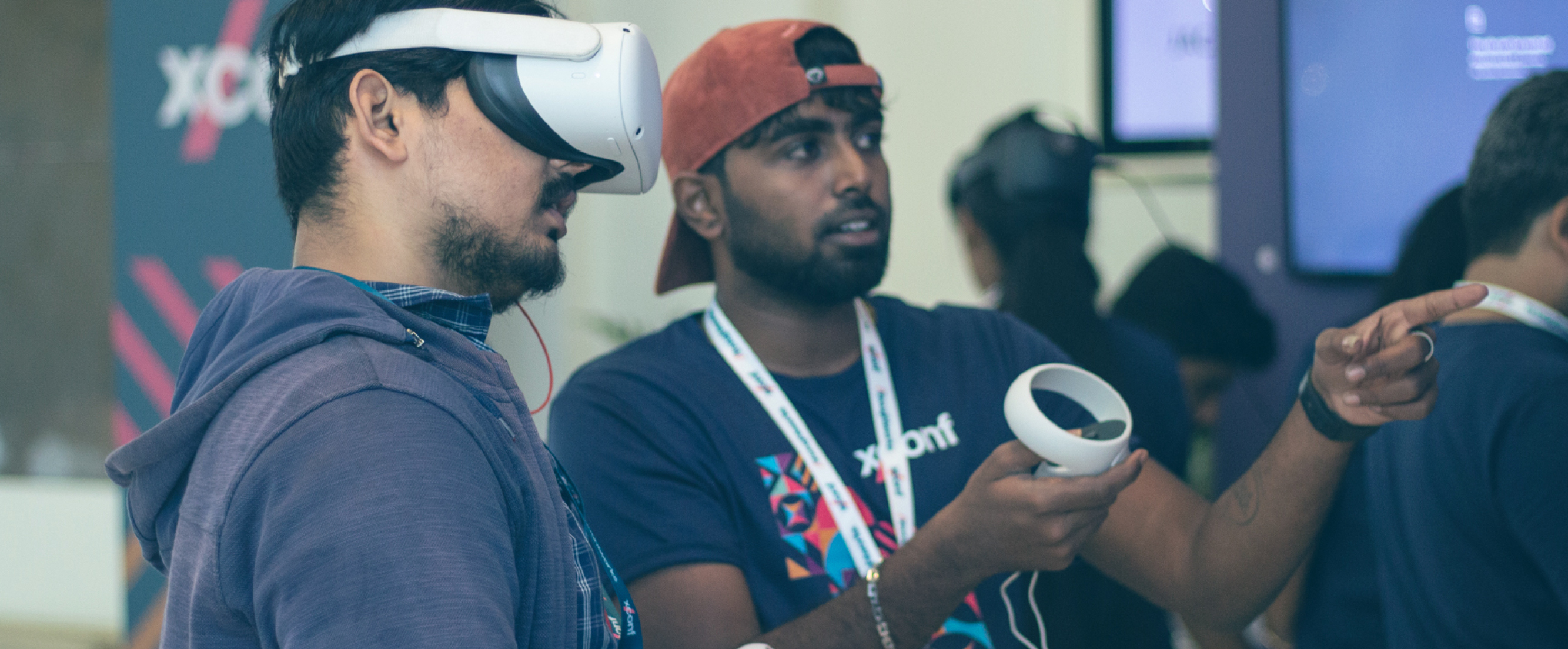 Photo of two men wearing virtual reality glasses at the XConf conference.